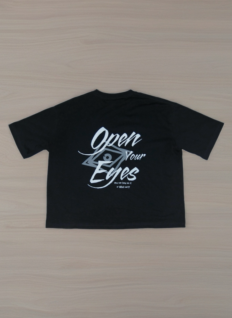 Vision Exclusives “Open Your Eyes” T Shirt Black t-shirt with white text on a wooden surface